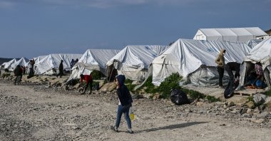 A child walks past tents inside the new refugee camp of Kara Tepe in Mytilene, on Lesbos, Greece, March 29, 2021. (AFP Photo)
