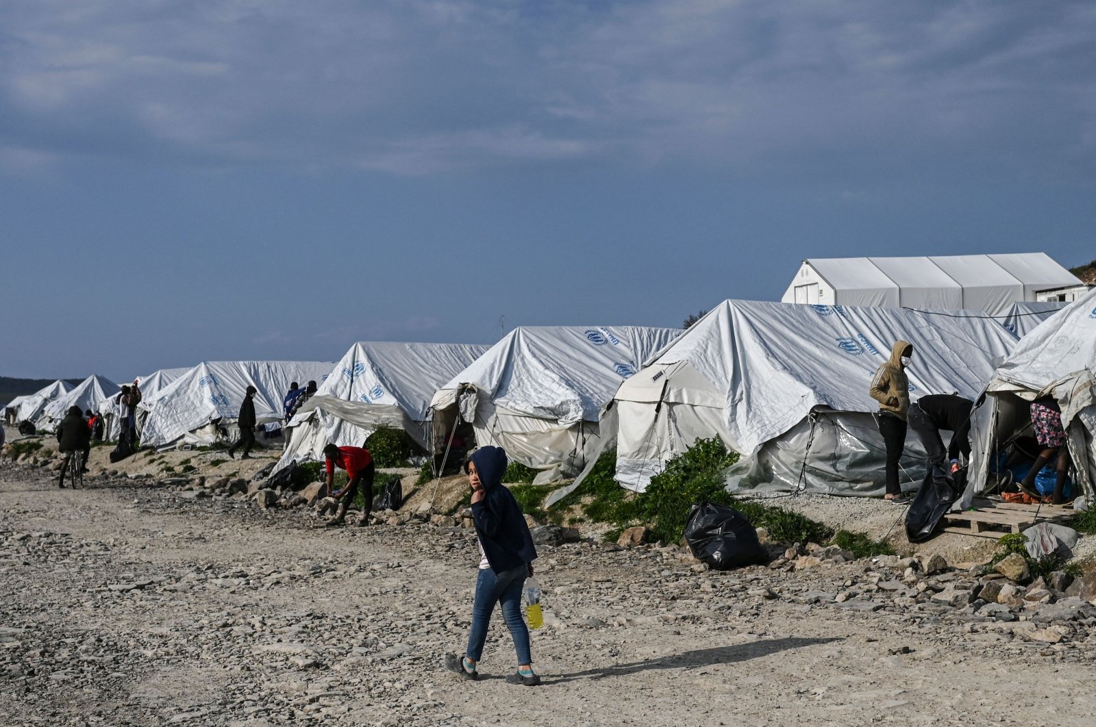 A child walks past tents inside the new refugee camp of Kara Tepe in Mytilene, on Lesbos, Greece, March 29, 2021. (AFP Photo)