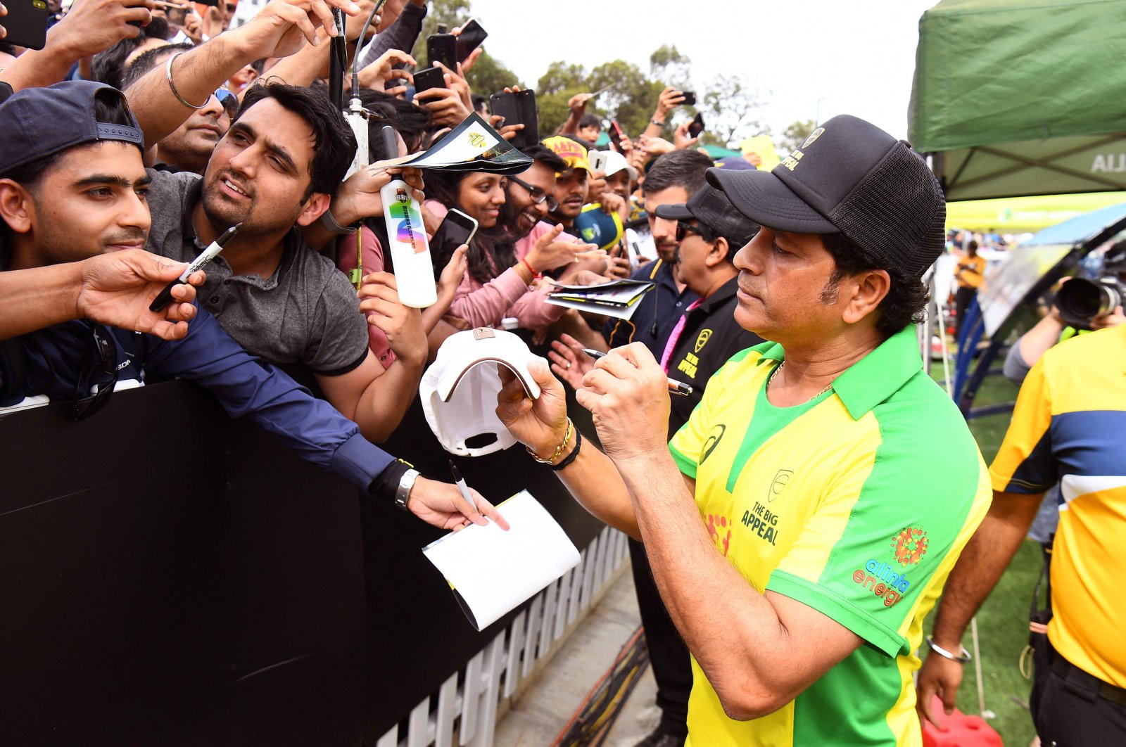 Former Indian player Sachin Tendulkar (R) signs autographs during a celebrity cricket match to raise funds for people affected by the Australian bushfires, in Melbourne, Australia, Feb. 9, 2020 (AFP Photo)