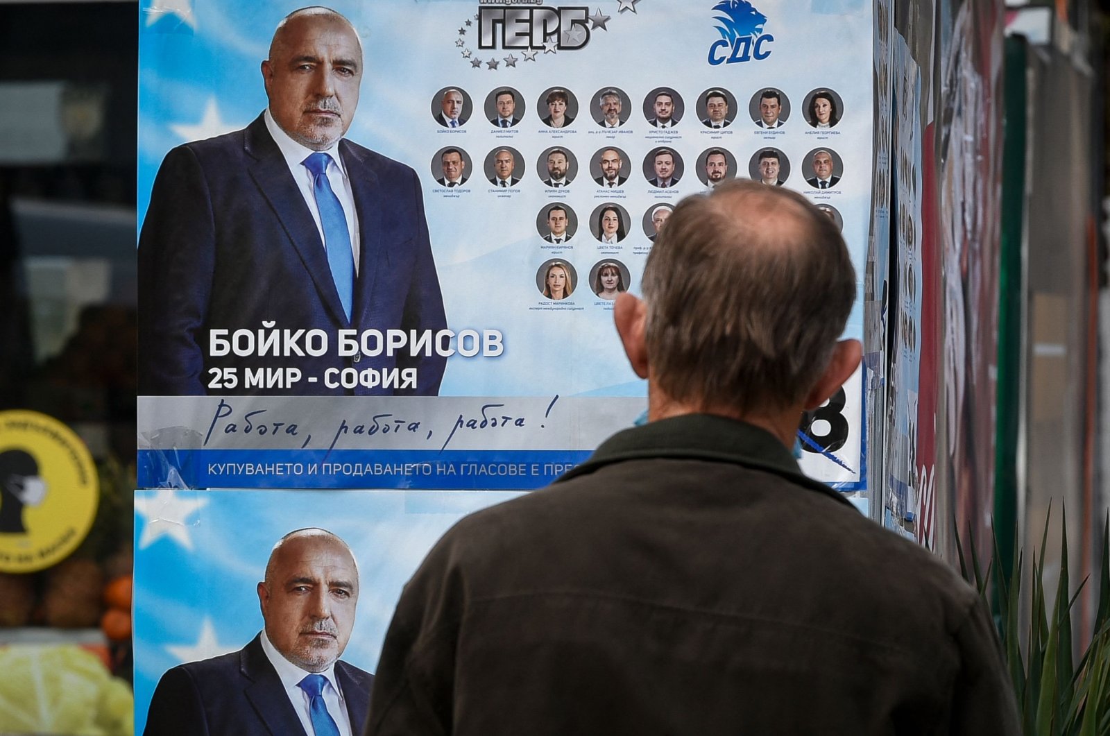 A man looks at election posters of Bulgarian Prime Minister and leader of center-right GERB party Boyko Borissov, Bankya, Bulgaria, on April 2, 2021. (AFP)