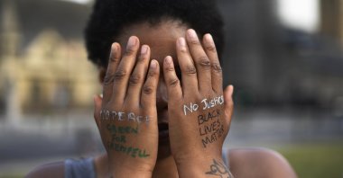 A woman symbolically covers her eyes as she participates in a Black Lives Matter protest calling for an end to racial injustice, at Parliament Square in central London, England, June 21, 2020. (AP Photo)