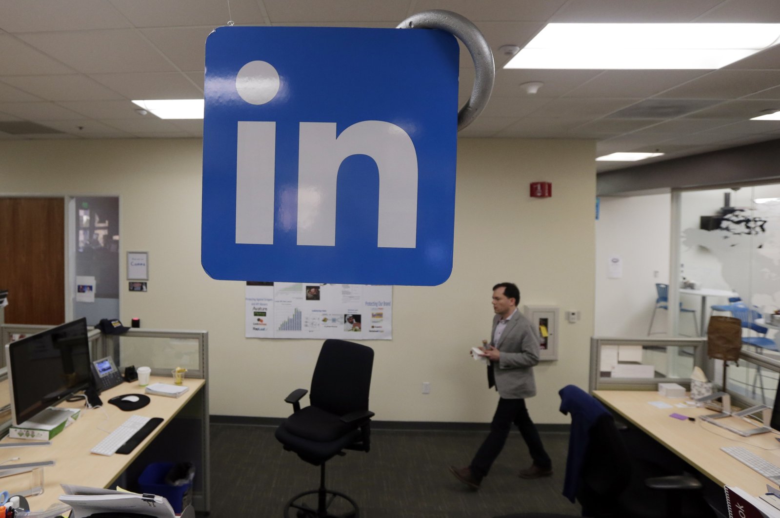 A LinkedIn employee walks past a company logo at the company's headquarters in Mountain View, California, U.S., Nov. 6, 2014. (AP Photo)