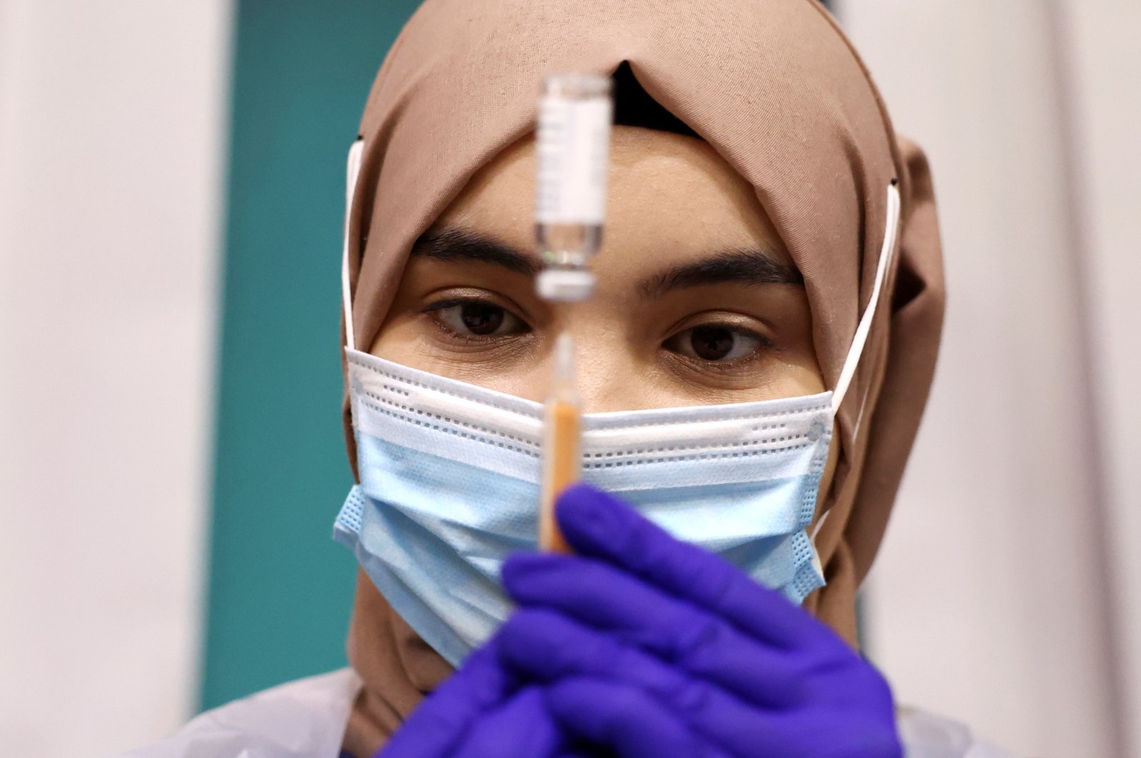 A medical worker prepares an injection with a dose of AstraZeneca coronavirus vaccine, at a vaccination center at the Baitul Futuh Mosque in London, England, March 28, 2021. (Reuters Photo)