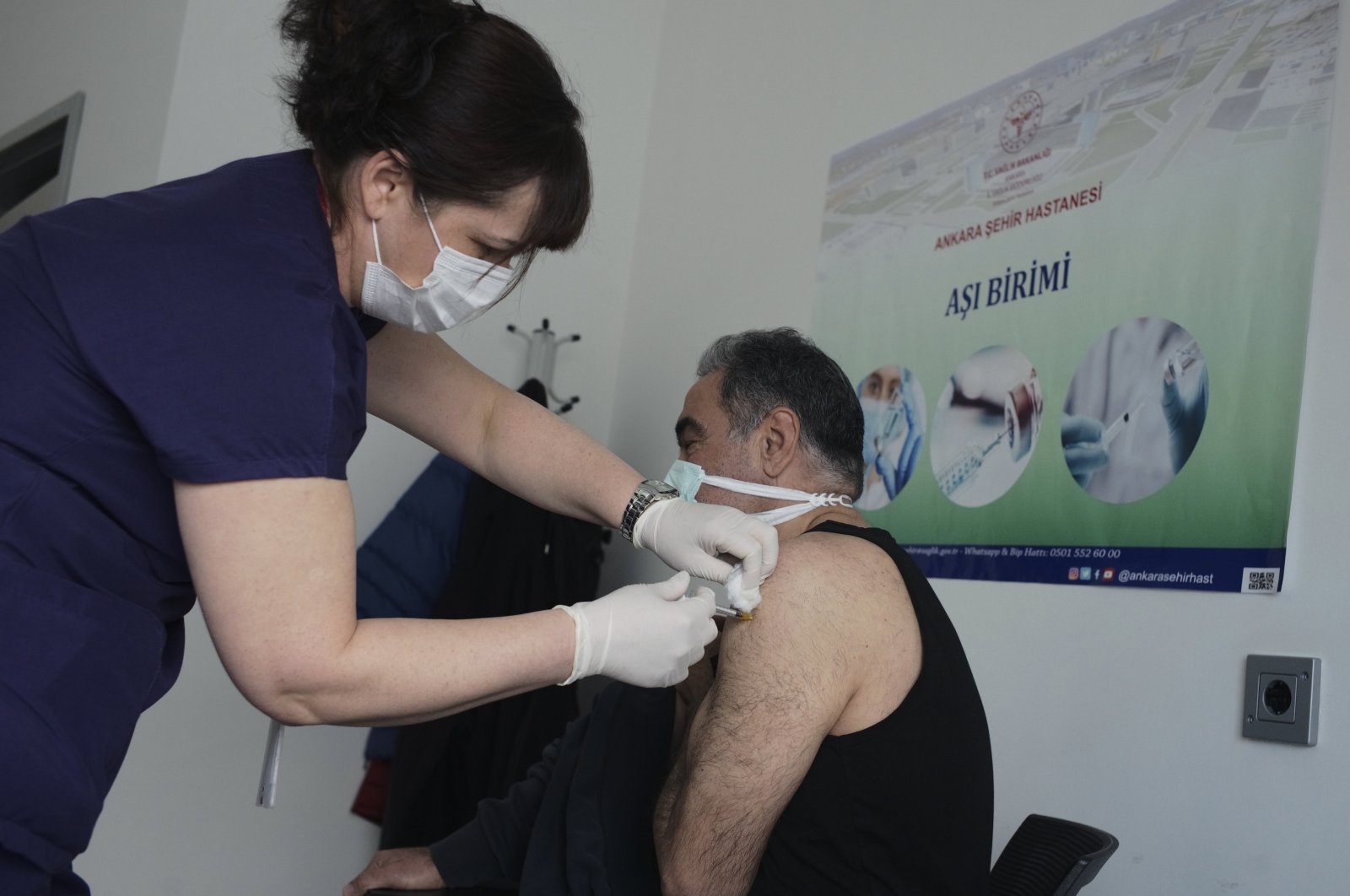Nurse Fatma Gökçe administers the Pfizer/BioNtech COVID-19 vaccine to a person at a hospital, Ankara, Turkey, Saturday, April 3, 2021. (AP Photo)