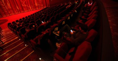 Moviegoers sit socially distanced as they wait for the movie "Godzilla vs. Kong" on the reopening day of the TCL Chinese theater during the outbreak of the coronavirus, Los Angeles, California, U.S., March 31, 2021.  (Reuters Photo)