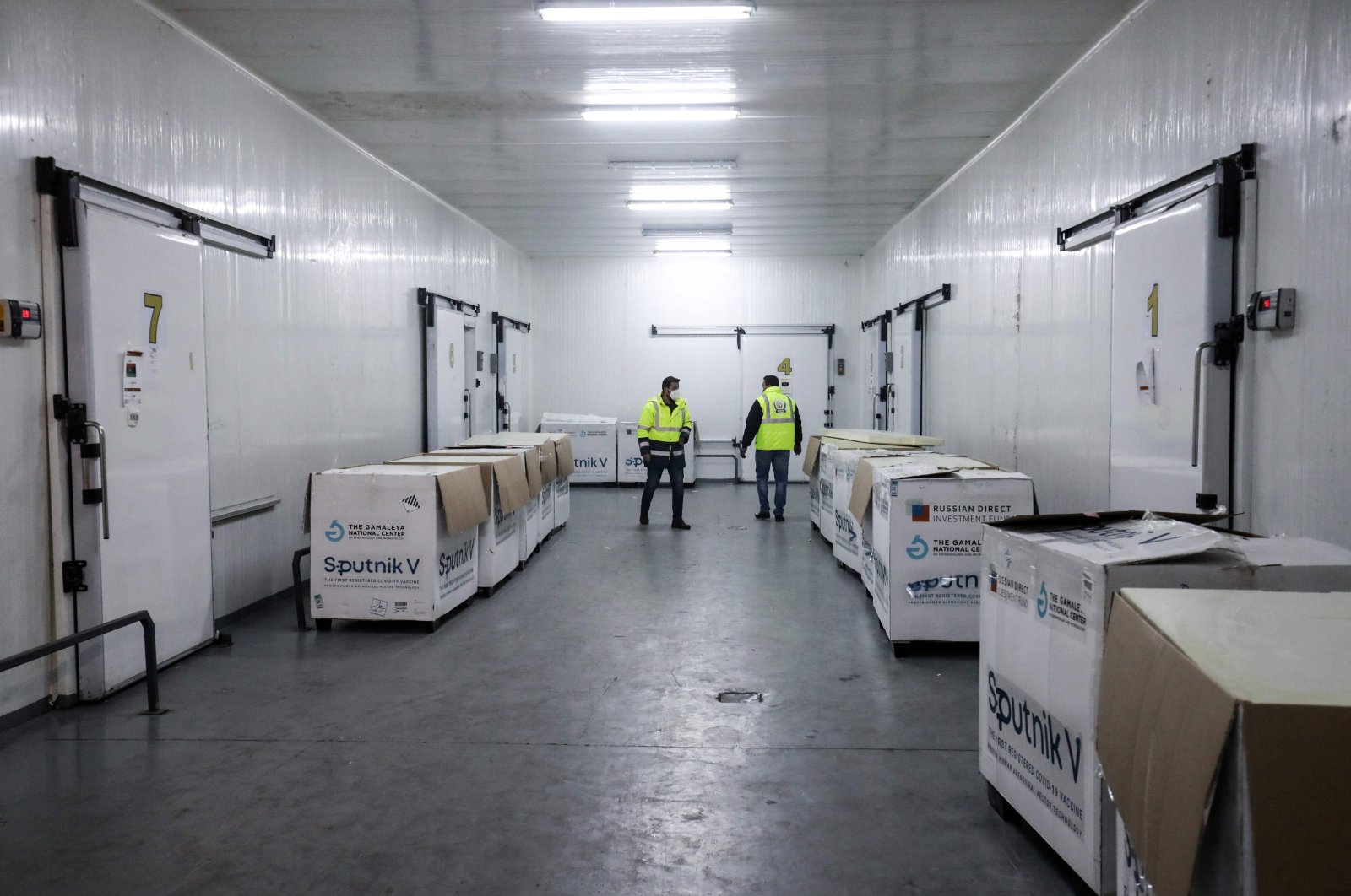 Workers handle boxes of the newly received first batch of the Russian Sputnik V vaccine against the coronavirus, before stockpiling them in refrigerated units inside the storage facilities of the Libyan health ministry, in the capital Tripoli, Libya, April 4, 2021. (AFP Photo)