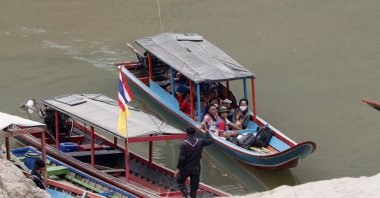 Karenni villagers from Myanmar arrive on a boat with an injured person as they evacuate to Ban Mae Sam Laep Health Center in Mae Hong Son province, northern Thailand, March 30, 2021. (AP Photo)