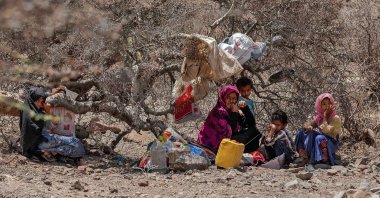 A displaced Yemeni family, who fled their homes due to fighting between Huthi rebels and Saudi-backed government forces, take shelter under a tree west of the suburbs of Yemen's third-largest city of Taez, April 1, 2021. (Photo by AHMAD AL-BASHA via AFP)