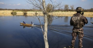 Fishermen sail along the Maritsa river as a Turkish special forces team patrols at the Turkish-Greek border near Karpuzlu village, in Edirne province, northwestern Turkey, March 11, 2020. (AP File Photo)