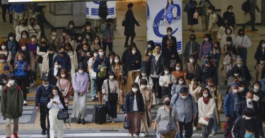 People wear face masks as they make their way in Osaka, western Japan, Wednesday, March 31, 2021. (AP Photo)