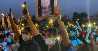 A Myanmar migrant living in Thailand holds a portrait of detained civilian leader Aung San Suu Kyi while others hold up their mobile phone lights during a night protest against the military coup in their homeland, Chiang Mai, Thailand, April 4, 2021. (AFP Photo)