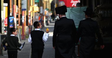 People walk past closed stores in the Borough Park section of Brooklyn, one of the five boroughs of New York City, on Oct. 9, 2020. (AFP Photo)