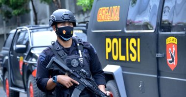 A policeman keeps watch outside the Santo Fransiscus Xaverius church ahead of religious services on Good Friday in Kuta, near Denpasar on Indonesia's resort island of Bali, April 2, 2021. (Photo by SONNY TUMBELAKA / AFP)