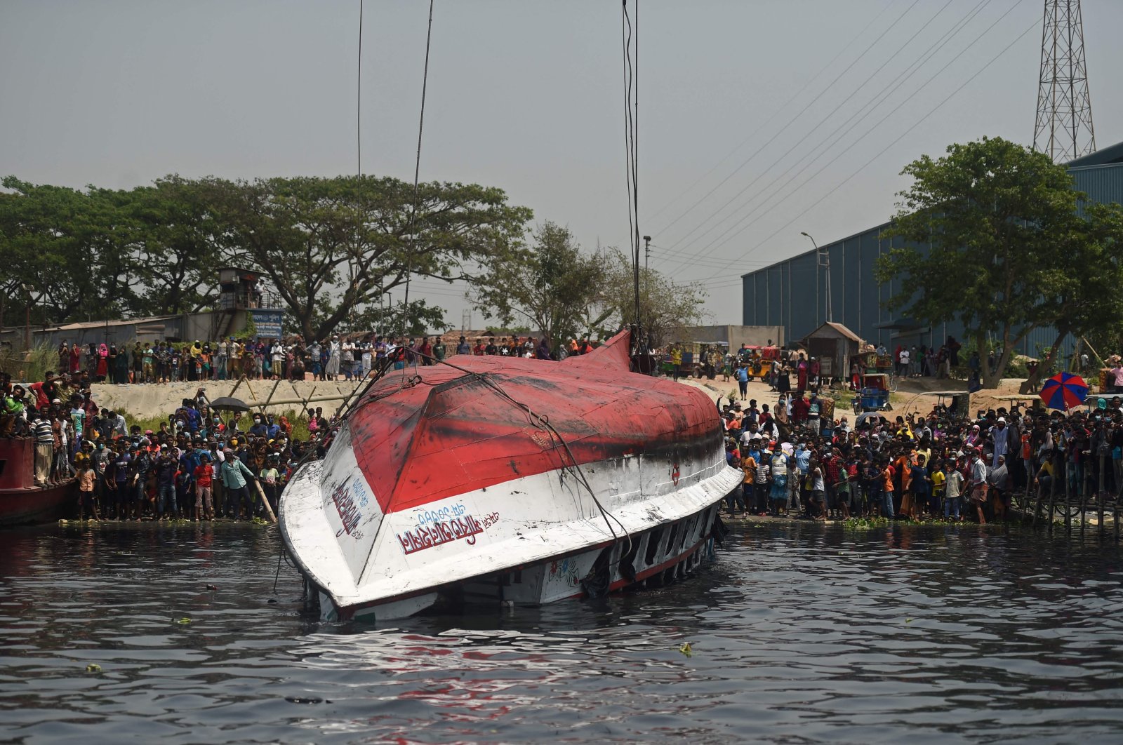 Onlookers and relatives gather after the authorities recovered the capsized boat in Shitalakshya River, in Narayanganj, Bangladesh, April 5, 2021. (AFP Photo)