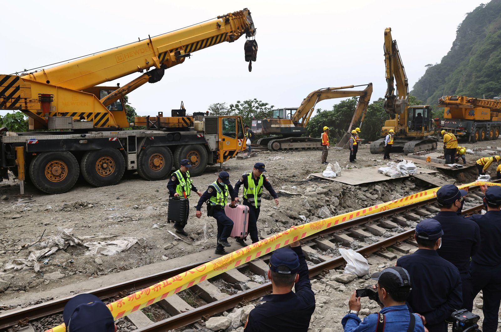 Police officers move passengers' belongings from the crash site a day after the deadly train derailment at a tunnel north of Hualien, Taiwan, April 3, 2021. (Reuters Photo)