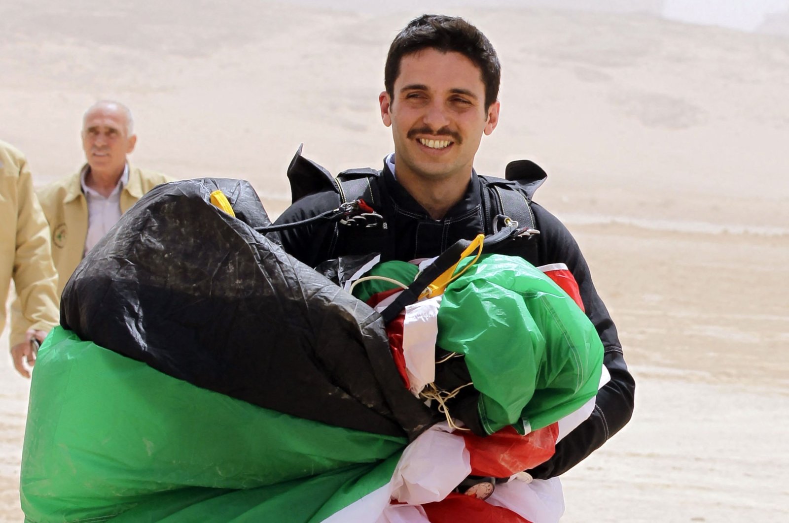 Jordanian Prince Hamza bin Al Hussein carries a parachute during a media event to announce the launch of "Skydive Jordan," in the Wadi Rum desert, Jordan, April 17, 2012. (AFP Photo)