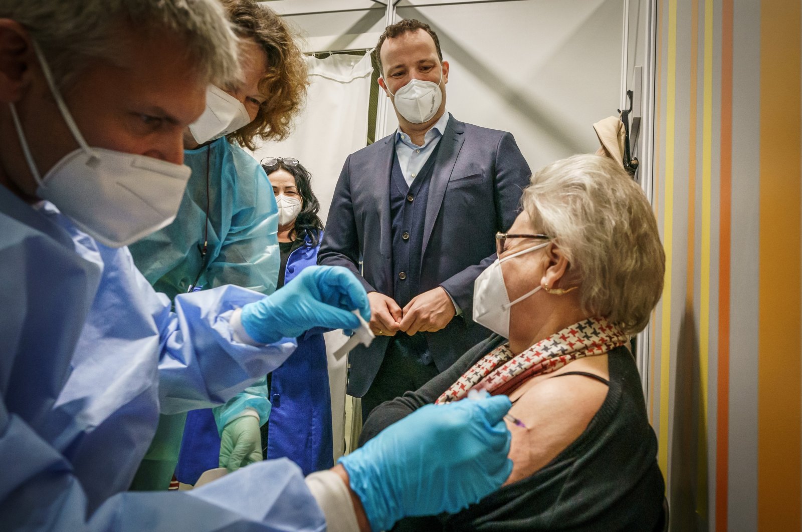 German Health Minister Jens Spahn watches doctor Tim Ratzloff vaccinate 80-year-old Rosemarie Langwald with the second dose of the Pfizer-BioNTech COVID-19 vaccine at the fairgrounds in Berlin, Germany, April 5, 2021. (Reuters Photo)