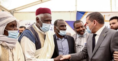 Libyan Prime Minister Abdul Hamid Dbeibah (R) shakes hands with elders at a rally during his visit to Tawergha, some 200 kilometers (125 miles) east of Libya's capital close to the port city of Misrata, April 3, 2021. (AFP Photo)