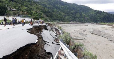 Residents inspect a damaged road following a flood in Dili, East Timor, April 5, 2021. (AP Photo)