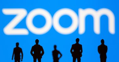 Small toy figures in front of the Zoom logo in this illustration picture taken March 15, 2021. (Reuters Photo)