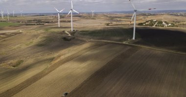 A Turkish farmer plows his fields with a tractor near wind turbines in the Istanbul countryside, Turkey, Oct. 22, 2020. (EPA Photo)
