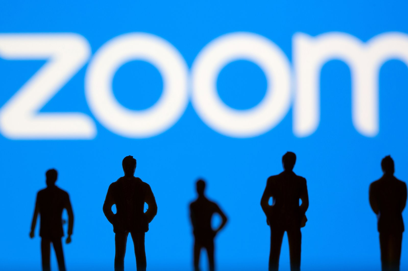 Small toy figures in front of the Zoom logo in this illustration picture taken March 15, 2021. (Reuters Photo)
