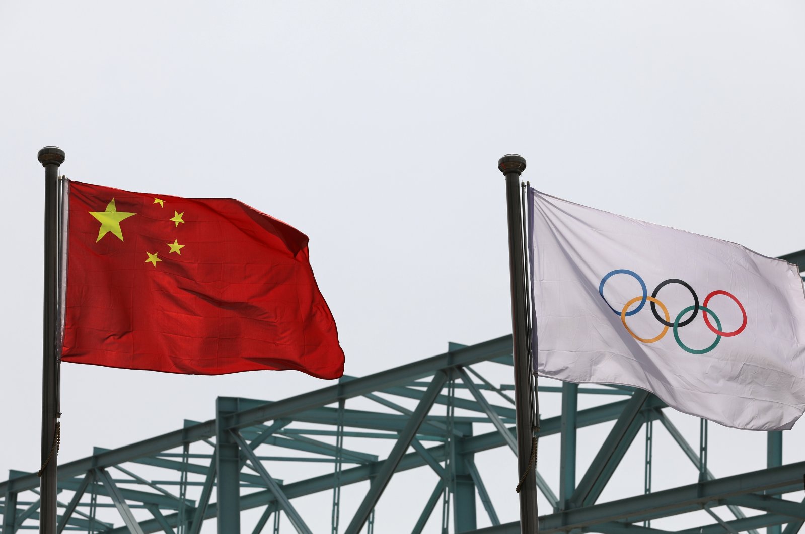 A Chinese national flag flutters next to an Olympic flag at the Beijing Organizing Committee for the 2022 Olympic and Paralympic Winter Games, in Beijing, China, March 30, 2021. (Reuters Photo)