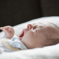A 5-week old baby yawns on a pillow on April 19, in Buecheloh, Germany. (Photothek via Getty Images)