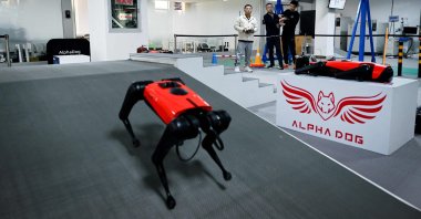 An engineer (background R) controlling an AlphaDog quadruped robot in a workshop at the Weilan Intelligent Technology Corporation in Nanjing, China's Jiangsu province, April 2, 2021. (AFP Photo)