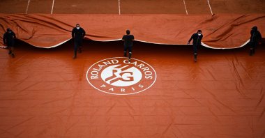 Ground staff members take off the cover across the Suzanne Lenglen court at The Roland Garros 2020 French Open in Paris, France, Sept. 28, 2020. (AFP Photo)