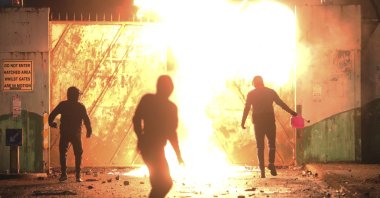Nationalists and loyalists clash with one another at the peace wall on Lanark Way in West Belfast, Northern Ireland, April 7, 2021. (AP Photo)