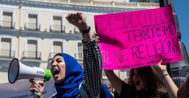 A woman uses a loudspeaker to call out slogans against terrorism with a placard in the background reading "Since when does terrorism have religion?" The Muslim community of Madrid gathered to reject terrorist attacks in Barcelona under the slogan "Not in my name," Madrid, Spain, Aug. 20, 2017. (Photo by Marcos del Mazo/LightRocket via Getty Images)