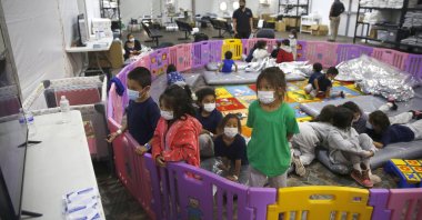 Young unaccompanied migrants, from ages 3 to 9, watch television inside a playpen at the U.S. Customs and Border Protection facility, the main detention center for unaccompanied children in the Rio Grande Valley, in Donna, Texas. U.S, on March 30, 2021. (AP Photo)