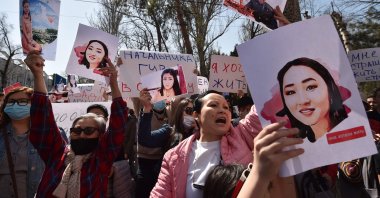 People hold pictures as they attend a rally for the protection of women's rights in Bishkek, Kyrgyzstan, on April 8, 2021. (AFP Photo)
