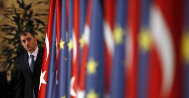 An official helps adjust the flags of Turkey and the European Union prior to the opening session of a high-level meeting the two sides, in Istanbul, Turkey, Thursday, Feb. 28, 2019. (AP File Photo)