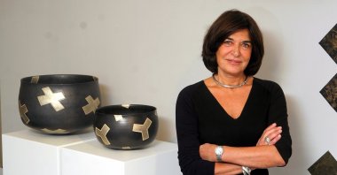 Alev Ebuziyya Siesbye poses with two of her ceramic works at one of her previous exhibitions at Gallery Nev in Istanbul, Turkey. (Sabah Photo)