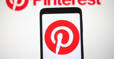 The Pinterest logo is seen on a smartphone and a pc screen in Ukraine, March 2, 2021. (Reuters Photo) 