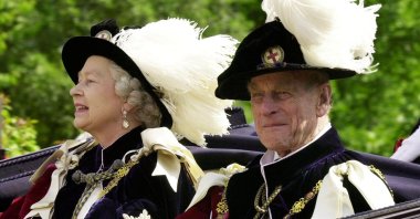 Britain's Queen Elizabeth II (L) and Prince Phillip, the Duke of Edinburgh, wearing their Order of the Garter robes, ride in an open-topped carriage to Windsor Castle following the Garter Ceremony, Windsor, U.K., June 18, 2001. (Reuters Photo)