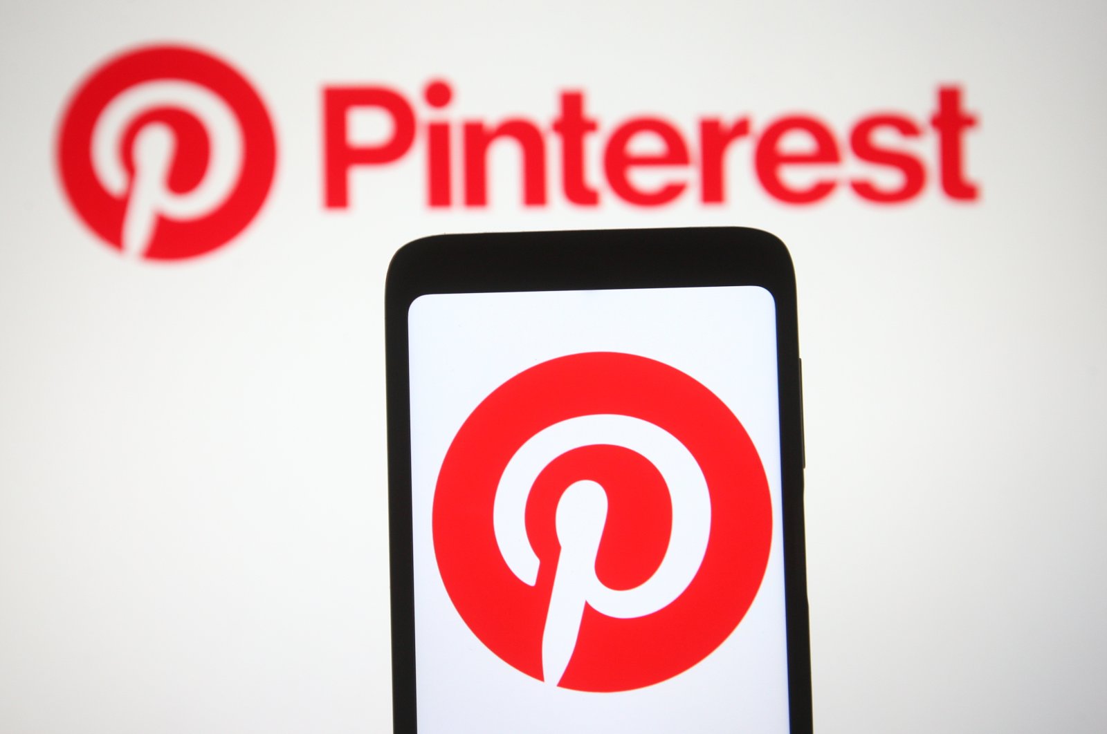 The Pinterest logo is seen on a smartphone and a pc screen in Ukraine, March 2, 2021. (Reuters Photo) 