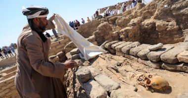 A man looks at skeletal human remains at the site of the 'Lost Golden City', which was recently discovered by archaeologists, in the West Bank of Luxor, upper Egypt, April 10, 2021. (Reuters Photo)