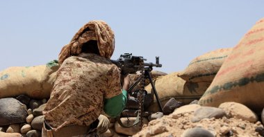 A fighter with forces loyal to Yemen's internationally-recognized government holds a position against Houthi rebels in Marib province, northwestern Yemen, April 6, 2021. (STR via AFP)