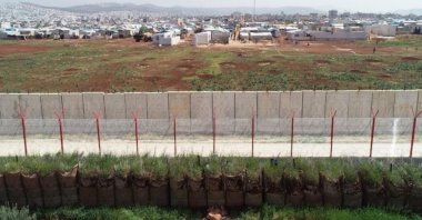 A section of the border running between Turkey and Syria is seen from the southern Turkish province of Hatay with the Syrian town of Atmeh in the background, April 10, 2021 (IHA Photo)