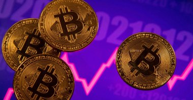 A representation of virtual currency Bitcoin in front of a stock graph in an illustration taken March 15, 2021. (Reuters Photo)