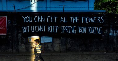 Children play with toy guns next to a banner put up by activists in protest against the military coup in Yangon, Myanmar, on April 11, 2021. (AFP Photo)