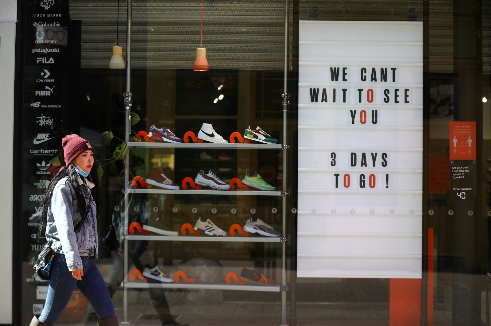 A pedestrian walks by a store being prepared for the reopening, as the coronavirus lockdown restrictions begin to ease, in London, Britain, April 9, 2021. (Reuters Photo)