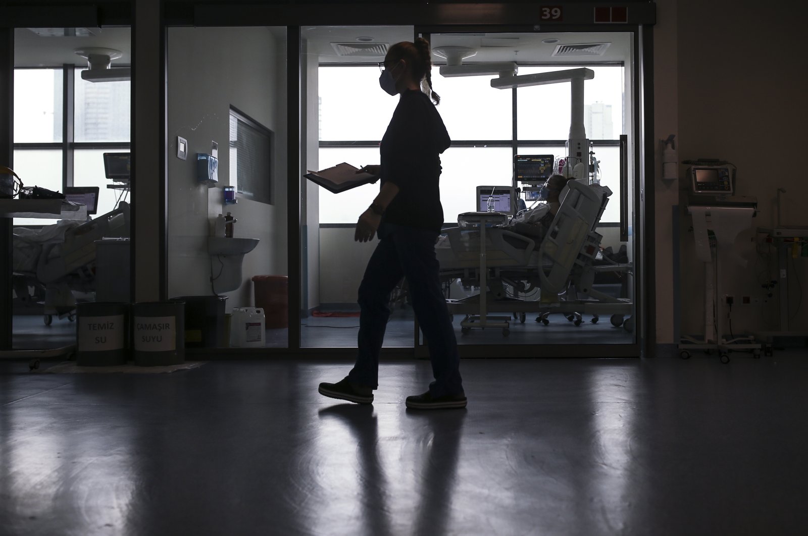 A nurse walks past a COVID-19 patient at the intensive care unit of a hospital, in Istanbul, Turkey, April 9, 2021. (AP PHOTO)