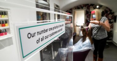 The owner of Hair & Beauty Gallery blow-dries a customer's hair as non-essential businesses reopen as COVID-19 lockdown restrictions begin to ease in Warwick, Britain, April 12, 2021. (Reuters Photo)