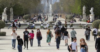 In this file photo, people wear face masks as they walk in the Tuileries garden in Paris, France, April 1, 2021. (AP Photo)