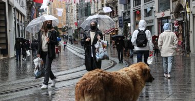 People tour the Istiklal street with umbrellas on a rainy day in Taksim district of Istanbul, Turkey, April 8, 2020. (AA)