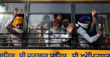 Sikh devotees wave from inside a bus as they leave for the border to cross into Pakistan to take part in the Baisakhi festival religious festivities, in Amritsar, India, 12 April, 2021. (EPA Photo)